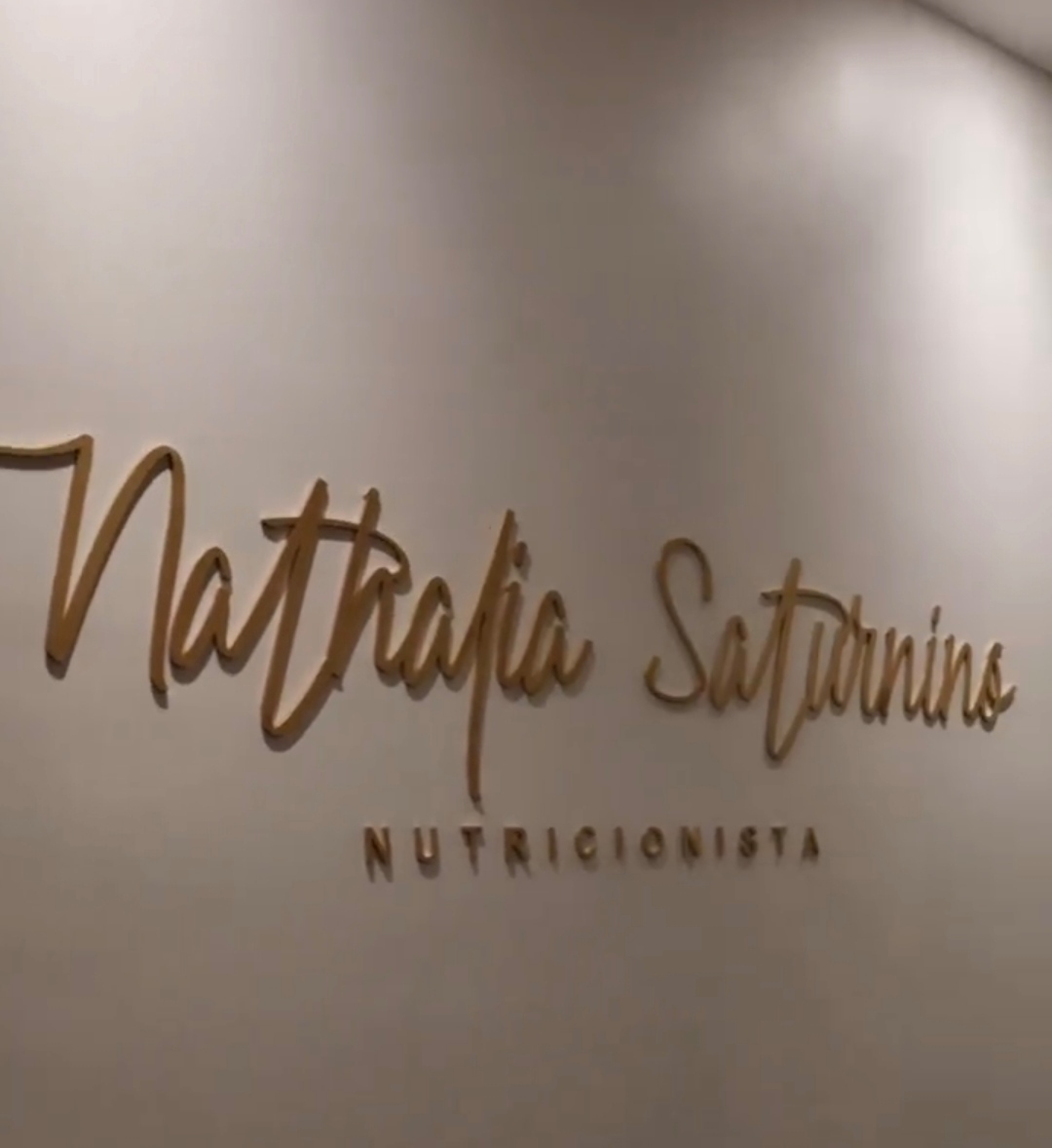 Letreiro dourado da clínica Nathália Saturnino.